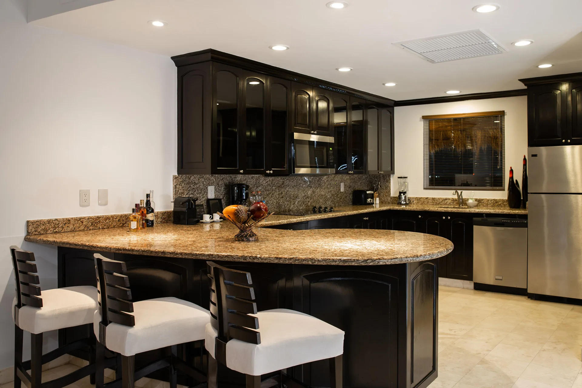 Two Bedroom Loft kitchen with granite island and bar stools at Villa del Palmar Cancun Beach Resort & Spa.