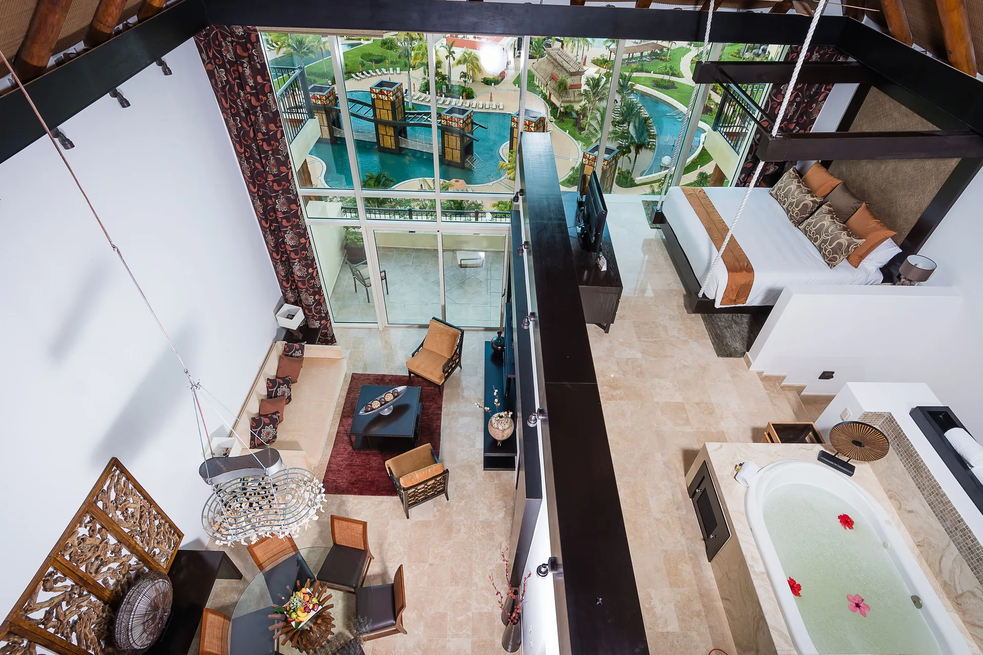 Two Bedroom Loft overview with living area, bed, tub, and pool view at Villa del Palmar Cancun Beach Resort & Spa.