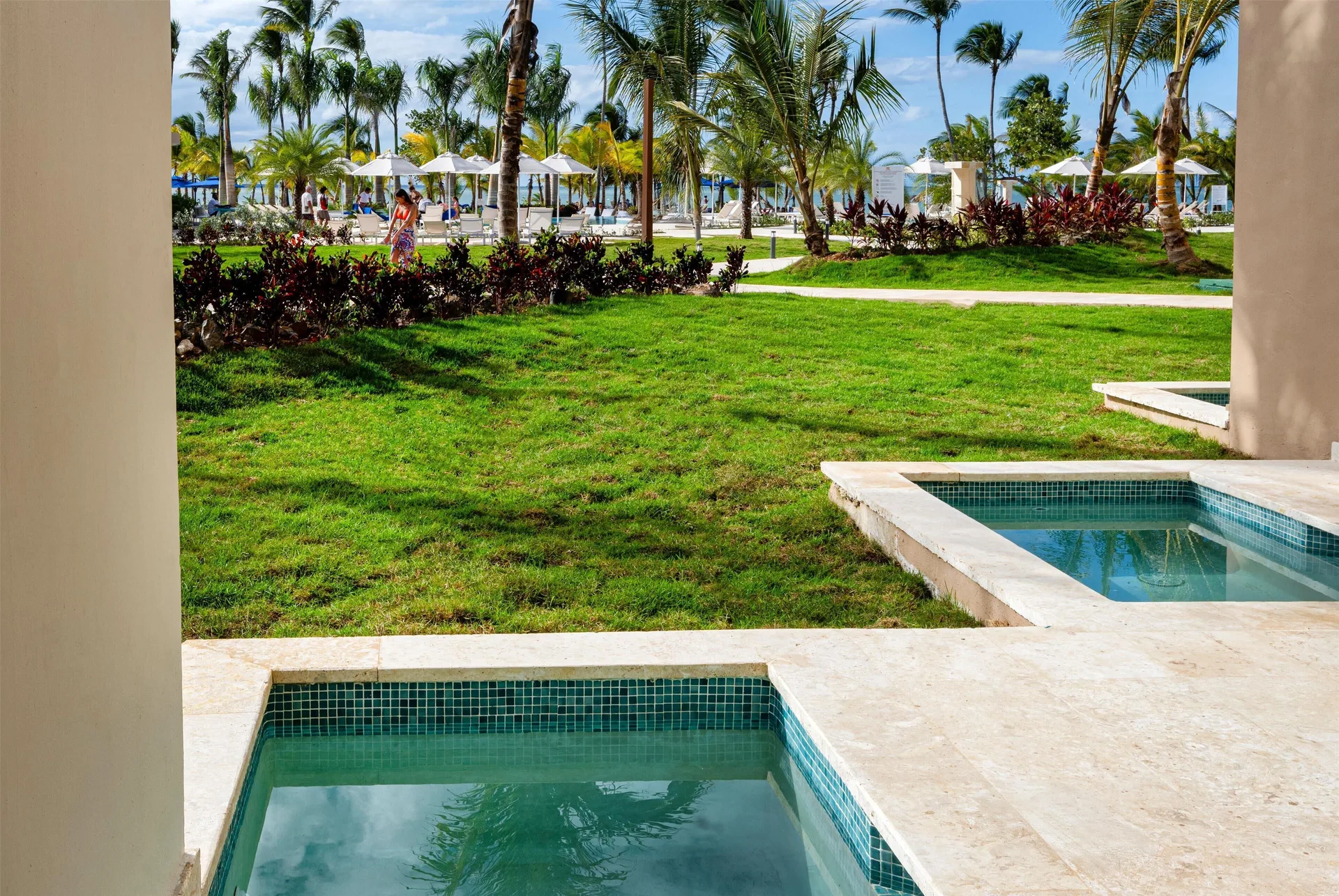 Garden patio plunge pools with palm-lined resort grounds at Viva Miches.