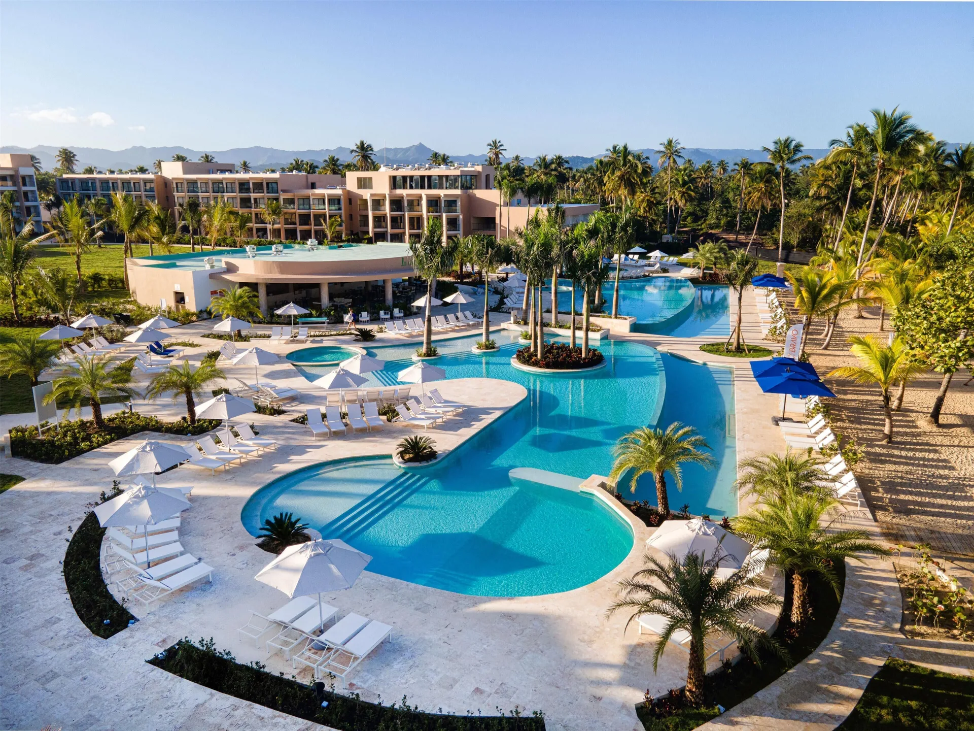 Elevated view of lagoon-style pools, palms, loungers, and resort buildings at Viva Miches.