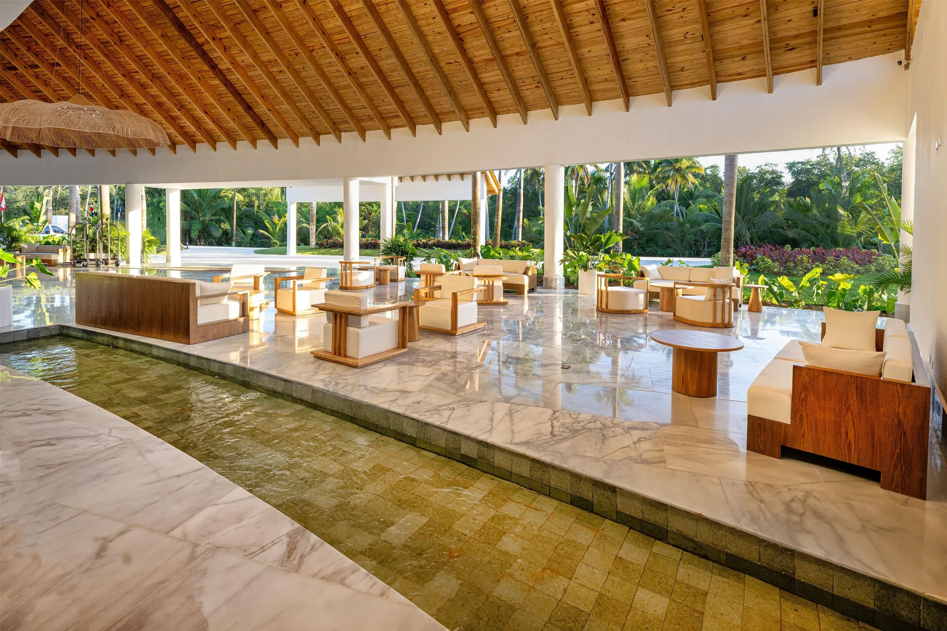 Lobby seating beside a shallow indoor water feature at Viva Miches.
