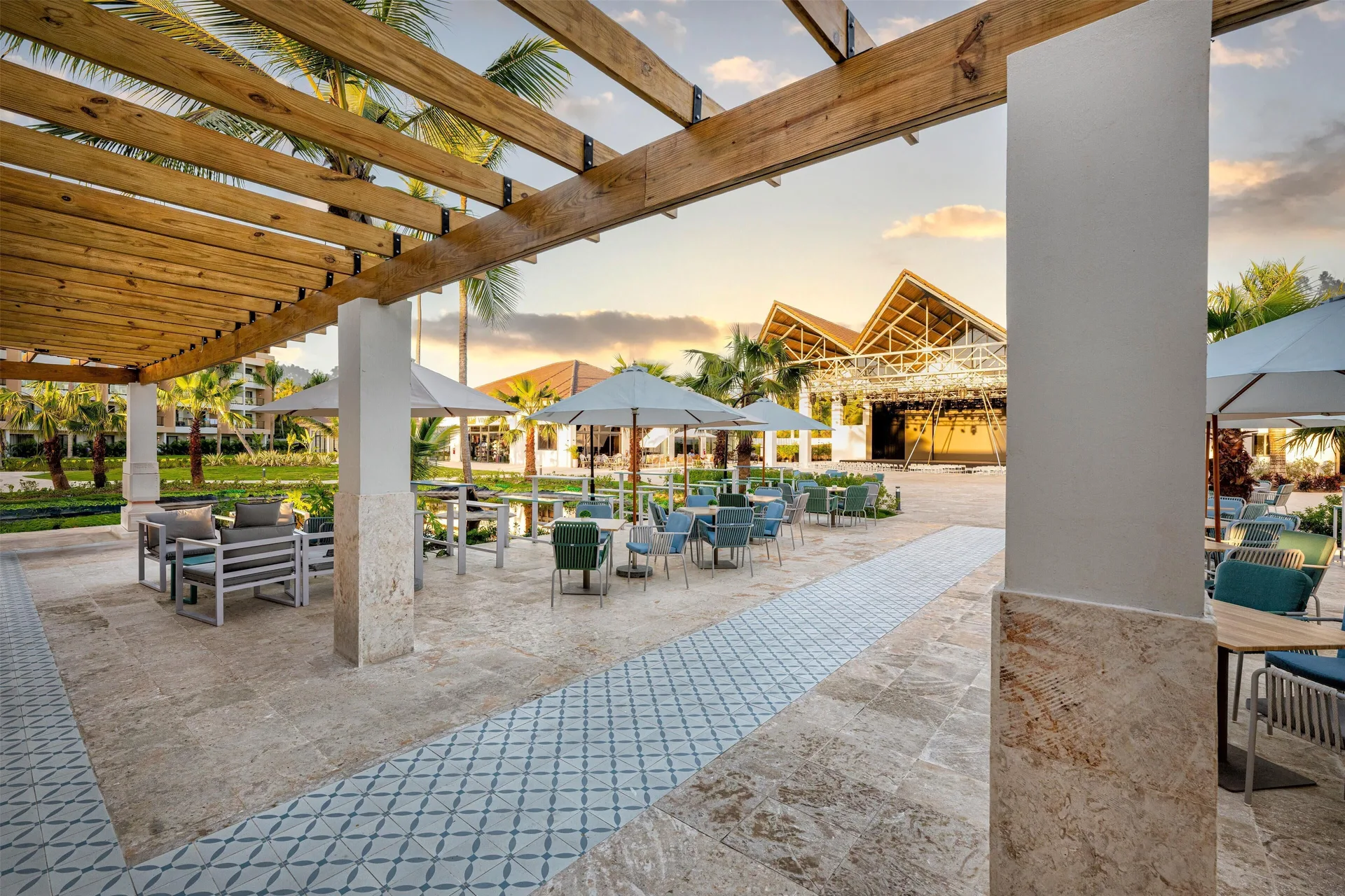 Pergola walkway with plaza seating and a stage area at Viva Miches.