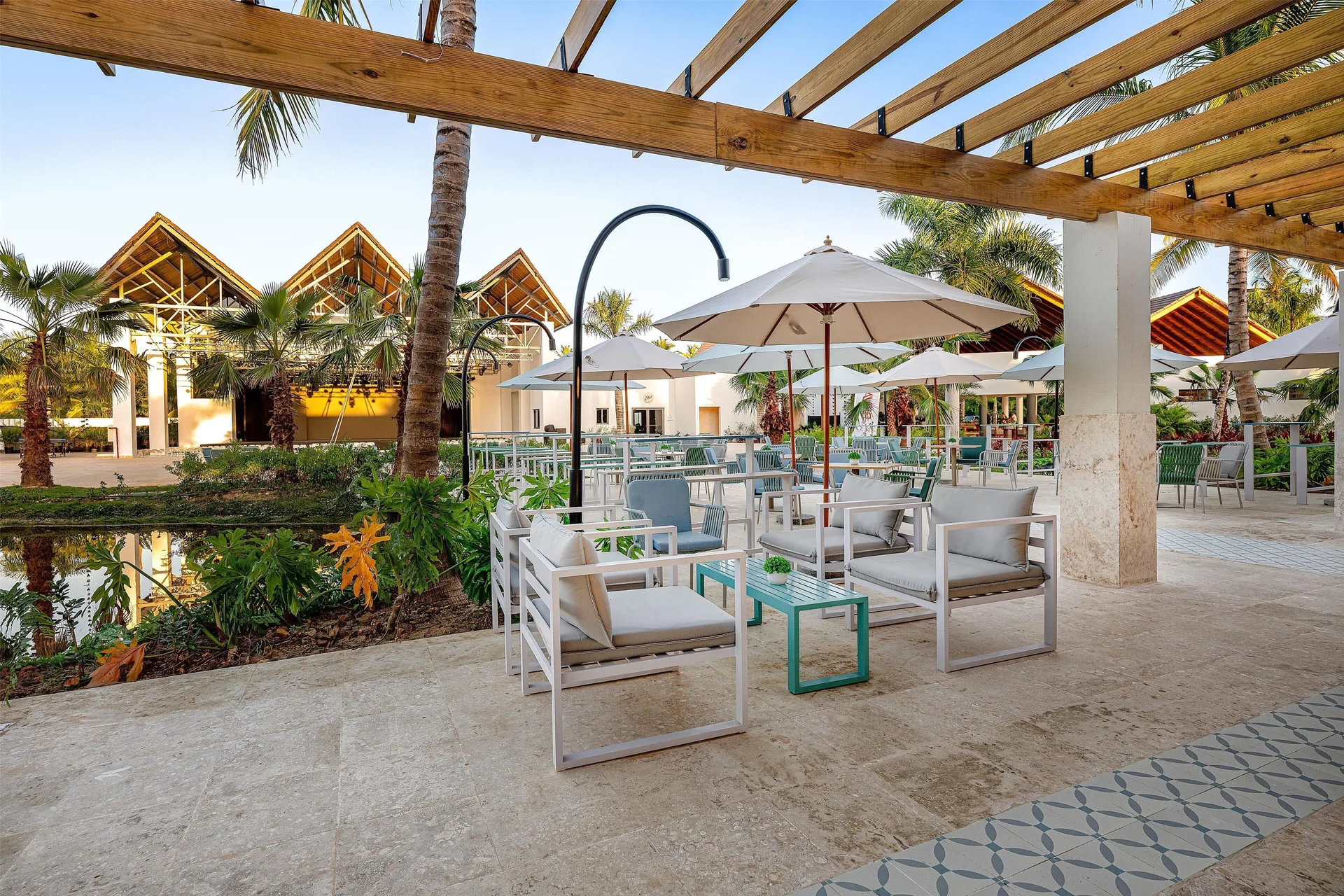Shaded outdoor lounge seating and umbrellas in the plaza at Viva Miches.