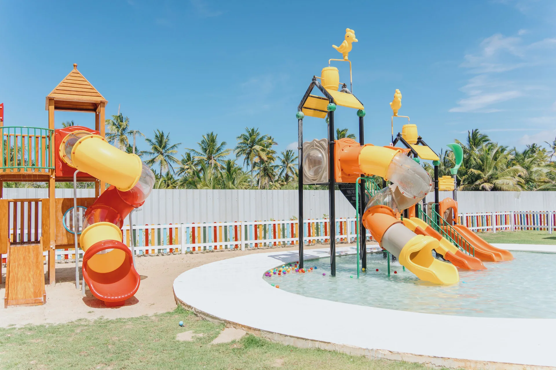 Colorful splash pad slides and water play towers at Viva Miches.