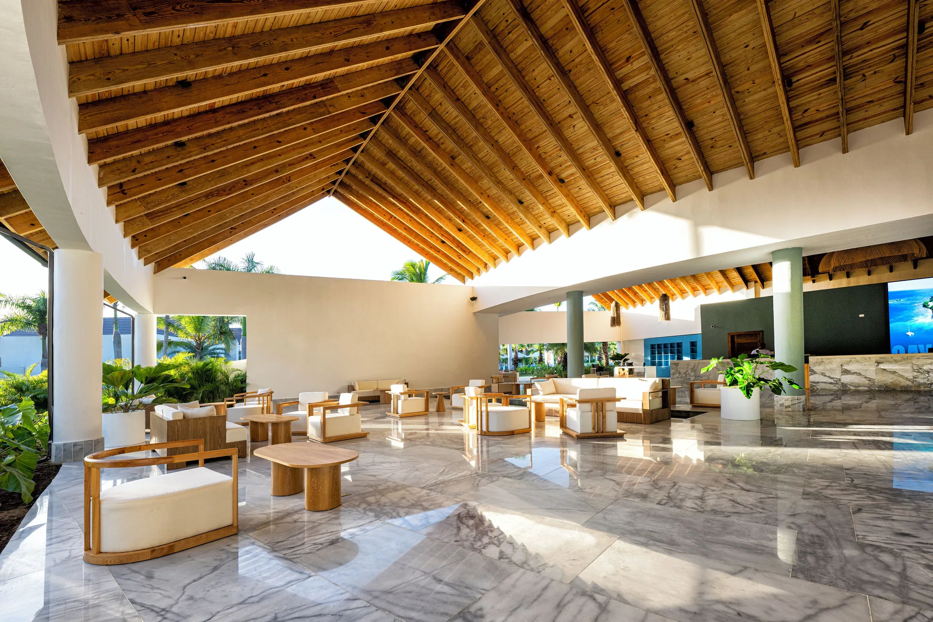 Sunlit lobby lounge with marble floors and wood ceiling at Viva Miches.