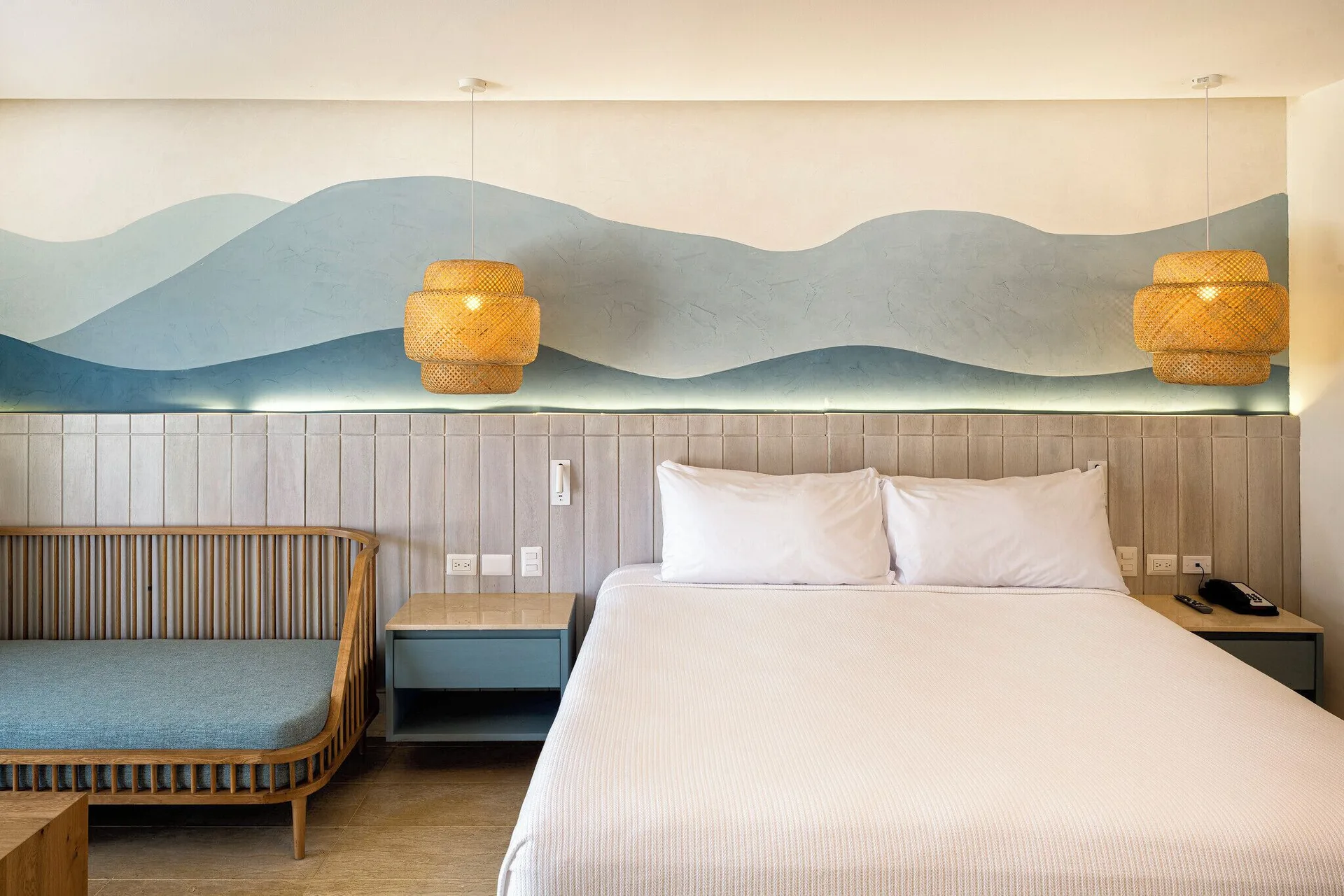 Splash Room king bed and daybed seating beneath a wave mural at Viva Miches.