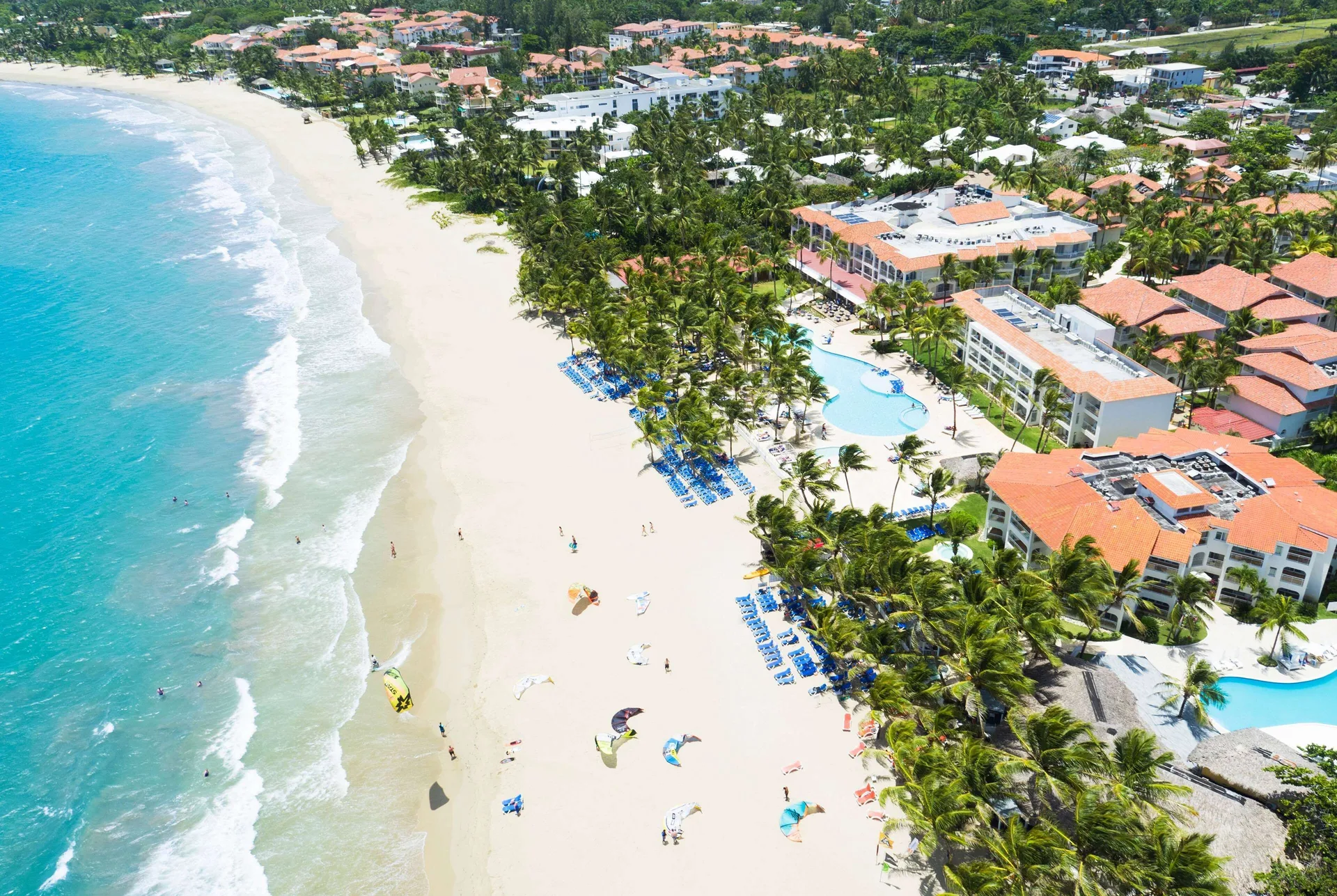 Aerial view of the beach, pools, palms, and resort buildings at Viva Tangerine.