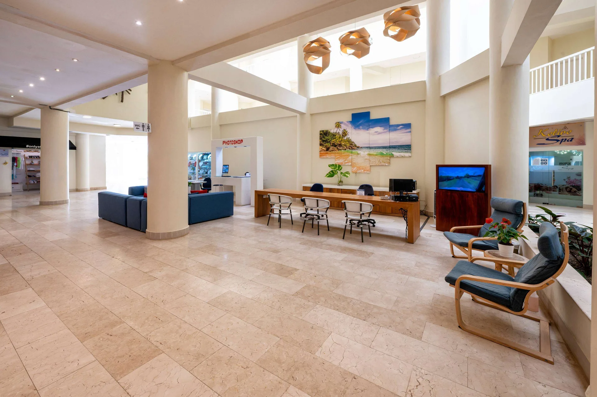 Bright interior concourse with seating, columns, and guest service desks at Viva Tangerine.