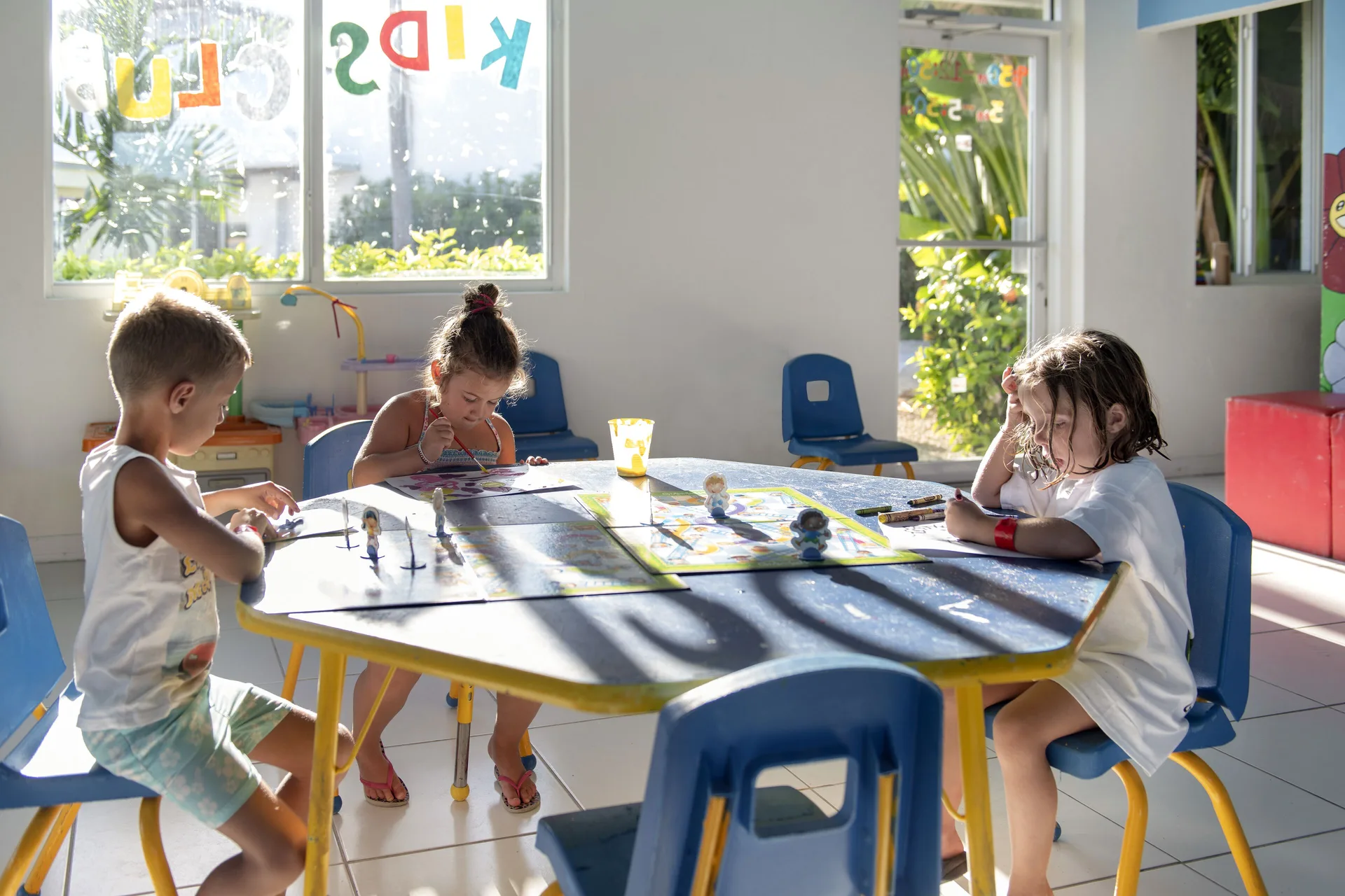 Children draw and play at a small indoor activity table at Viva Tangerine.