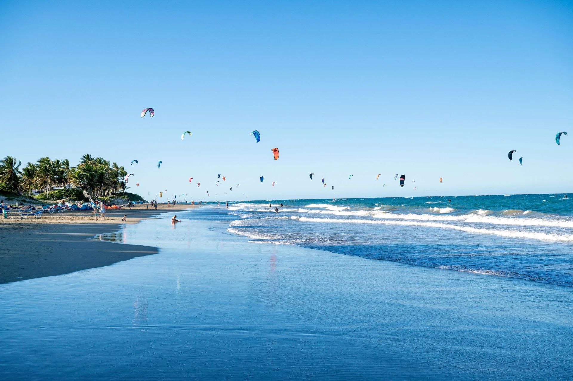 Kitesurfers ride offshore along the broad beach at Viva Tangerine.