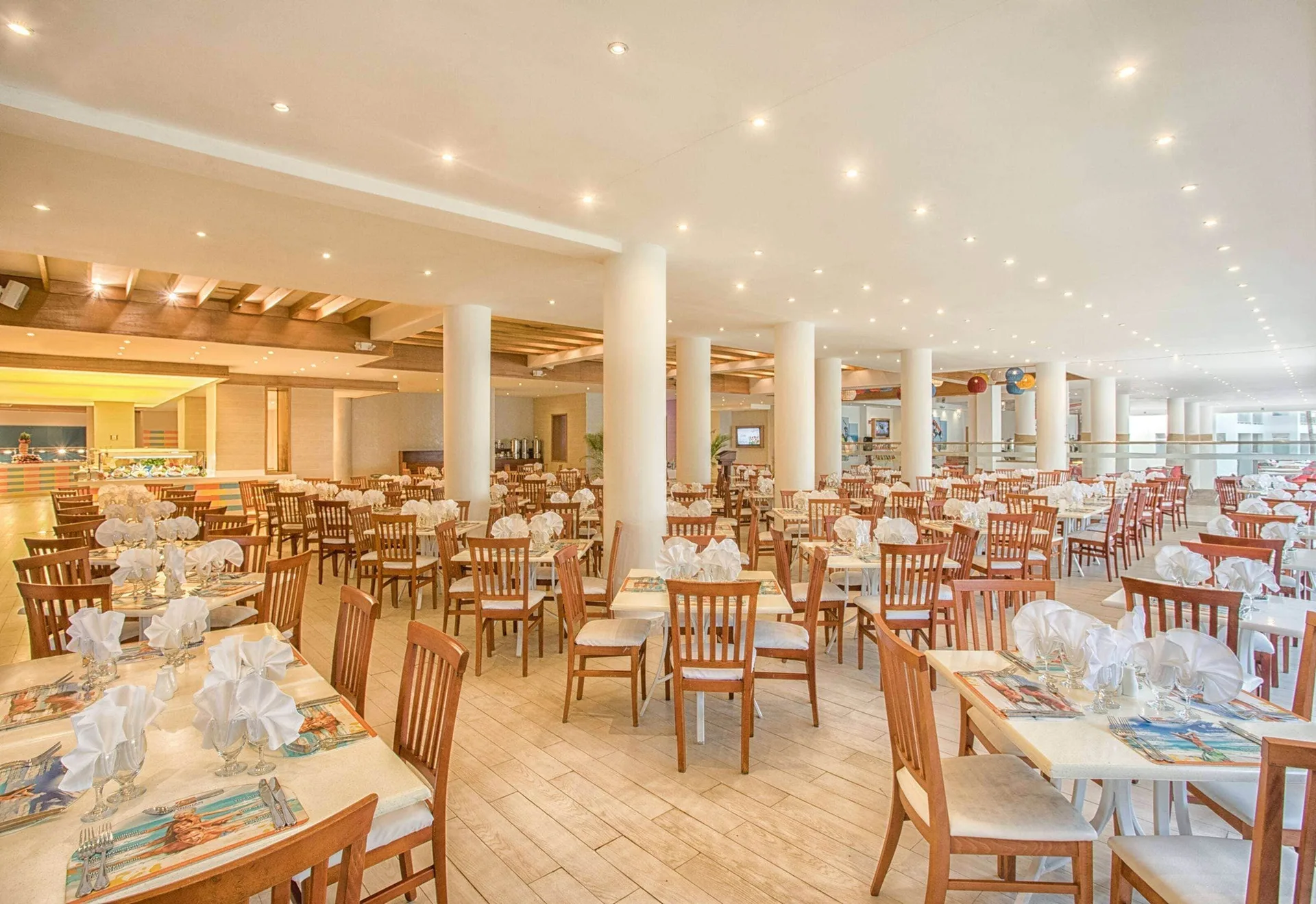 Large buffet dining room with set tables and white columns at Viva Tangerine.