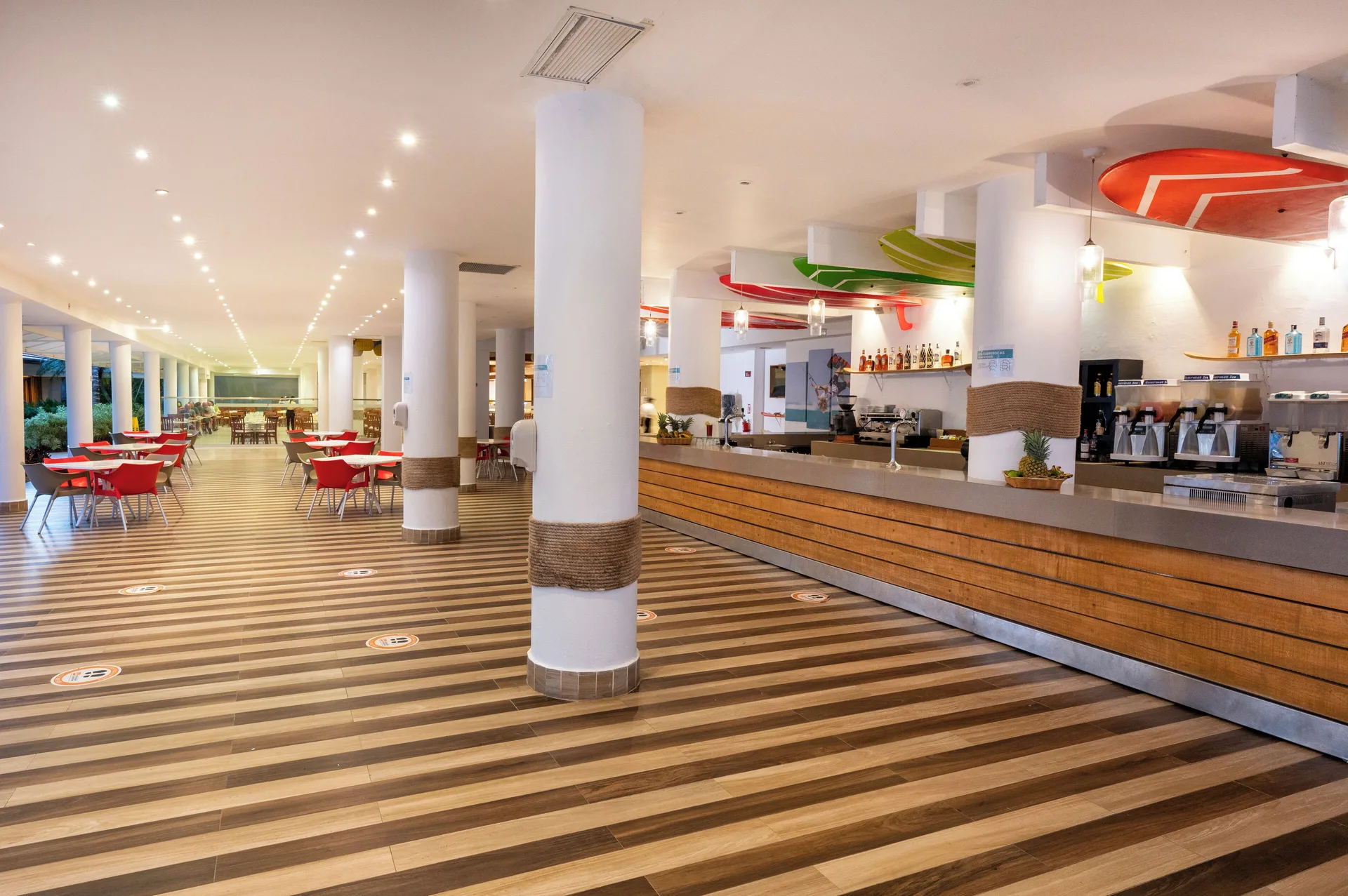 Long bar and seating area with striped flooring at Viva Tangerine.