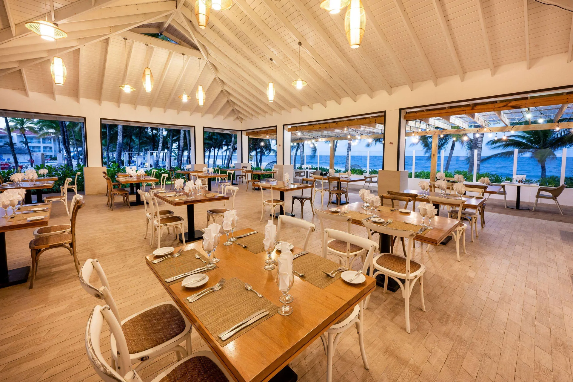 Open-air dining room with wooden tables and ocean views at Viva Tangerine.