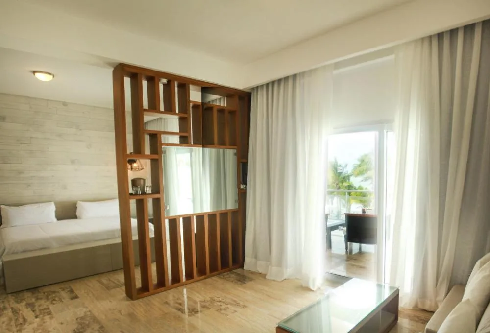 Accessible non-smoking room sitting area, bed, and balcony doorway at Viva Tangerine.