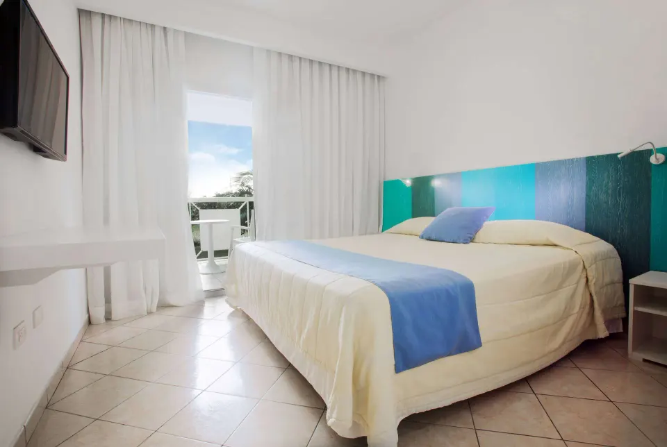 Superior Garden room with king bed, wall TV, and balcony doorway at Viva Tangerine.