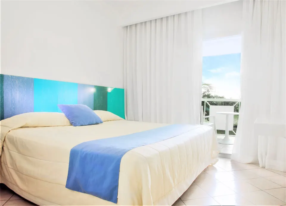 Superior Garden room with king bed and balcony seating visible through curtains at Viva Tangerine.