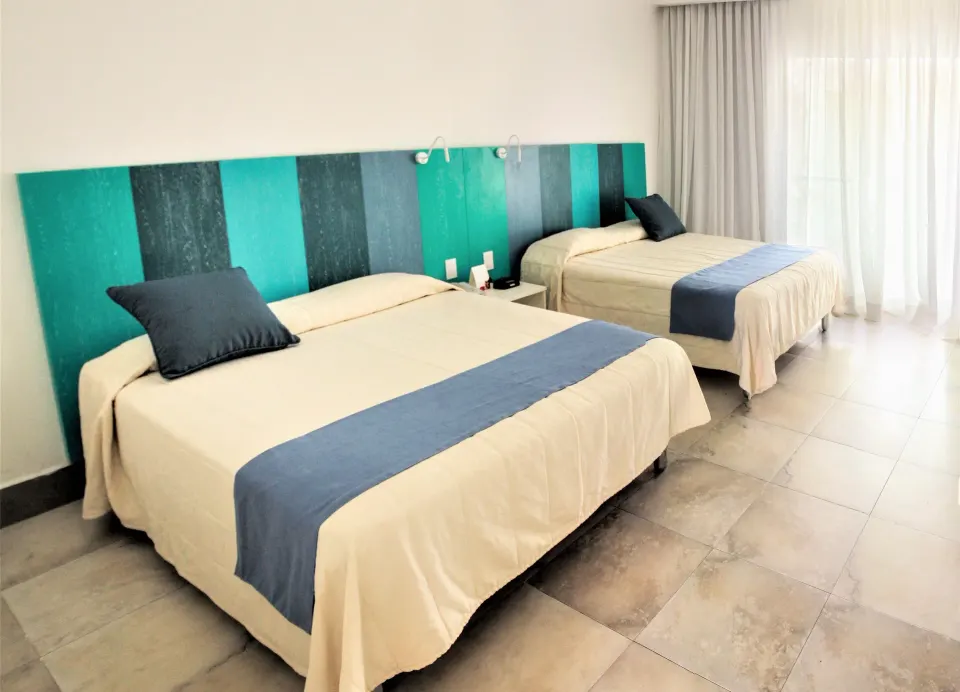 Superior Garden room with two beds, blue accents, and bright balcony curtains at Viva Tangerine.