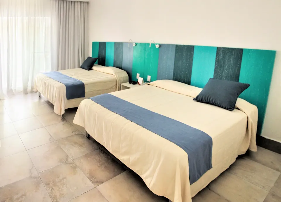 Superior Garden room with two beds, teal headboard panels, and balcony curtains at Viva Tangerine.