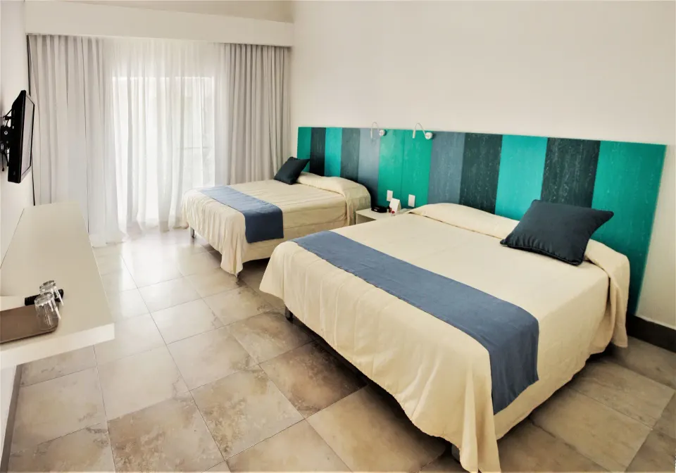 Superior Garden room with two beds, blue bed runners, and a wall TV at Viva Tangerine.