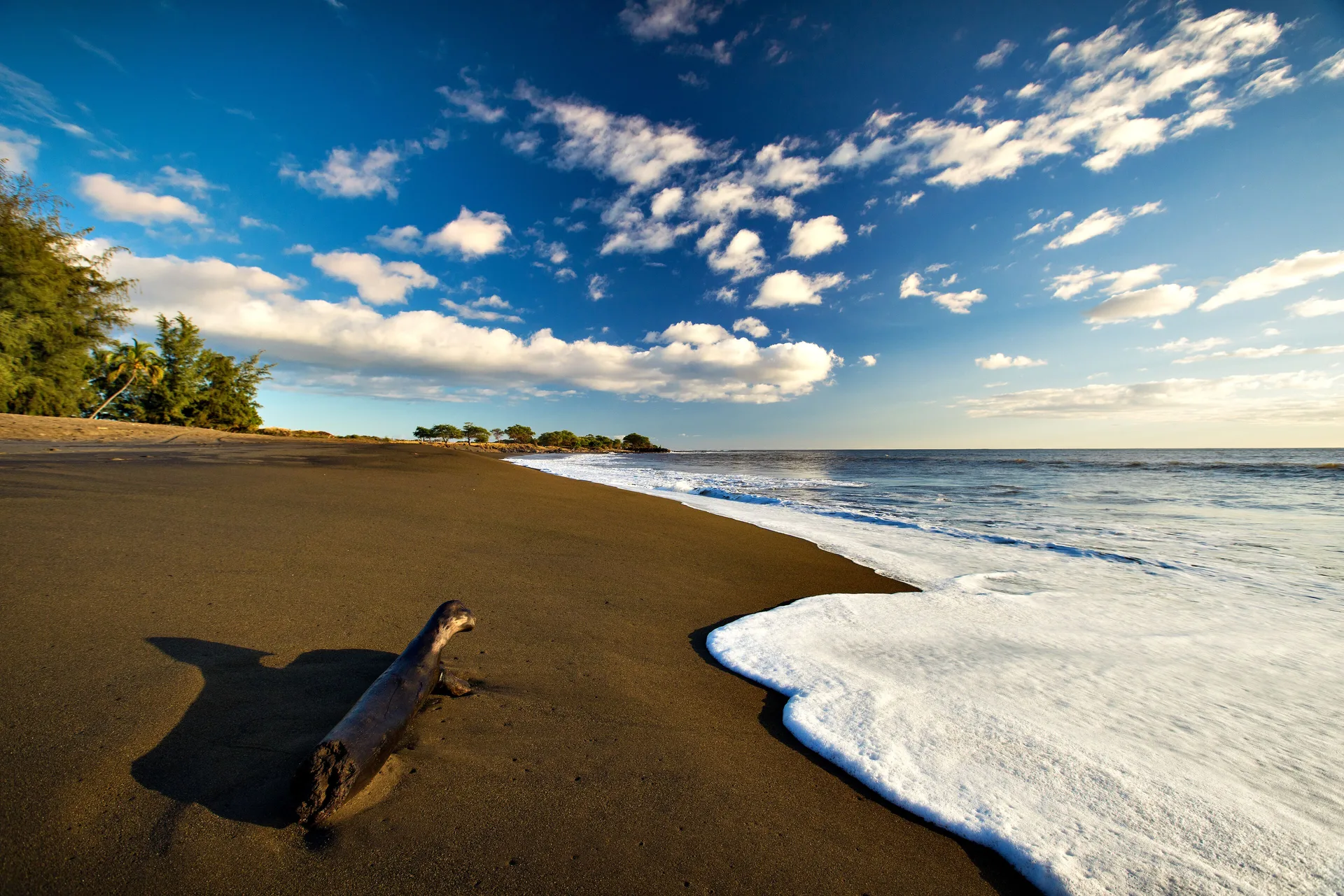 Black-sand beach and surf near Waimea Plantation Cottages.