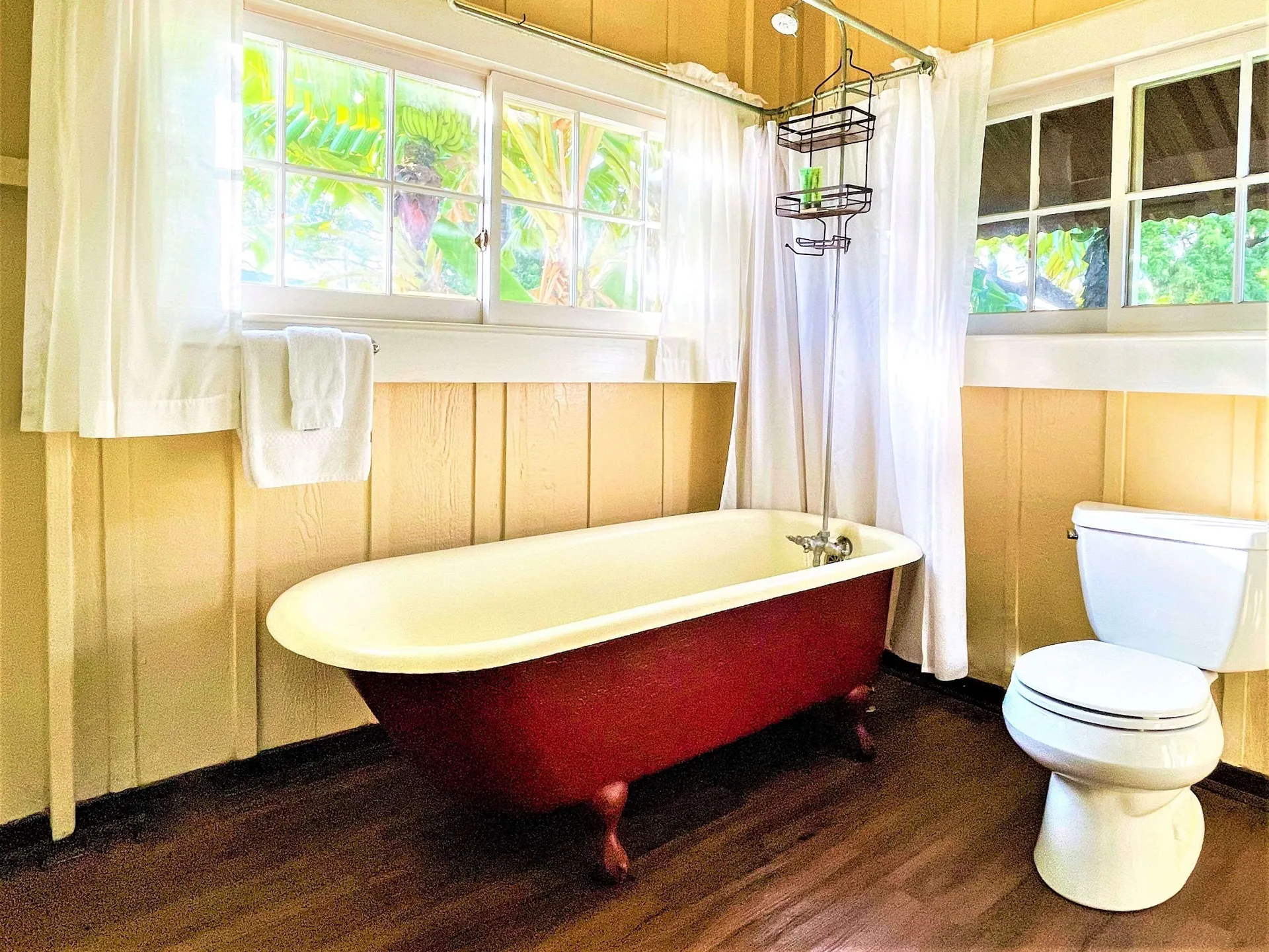 Coast Cottage bathroom with clawfoot tub and toilet at Waimea Plantation Cottages.