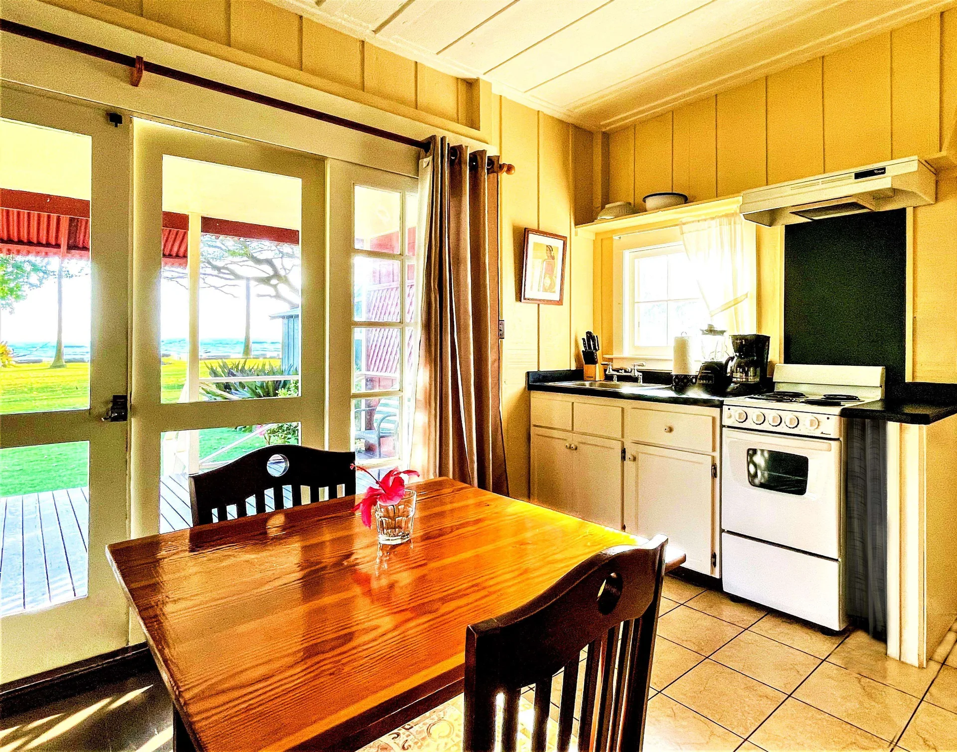 Coast Cottage kitchen and dining table with ocean beyond at Waimea Plantation Cottages.